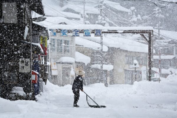 Japanese man removes snow during heavy snow storm.